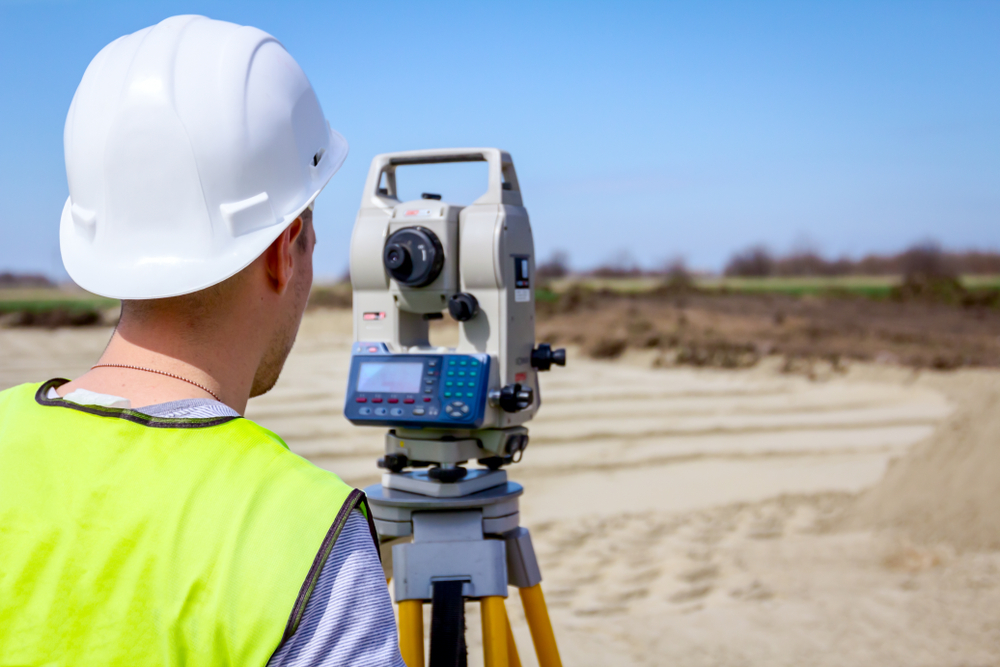 Surveyor,Engineer,Is,Measuring,Level,On,Construction,Site.,Surveyors,Ensure